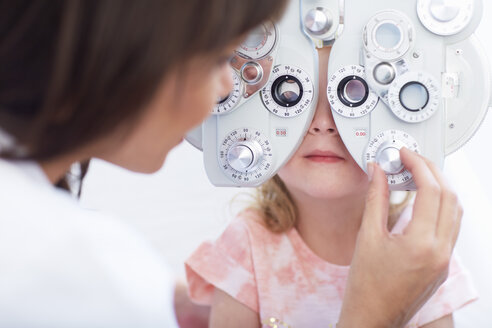 Eye doctor examining girl's vision - ZEF000599
