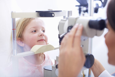 Eye doctor examining girl's vision - ZEF000600