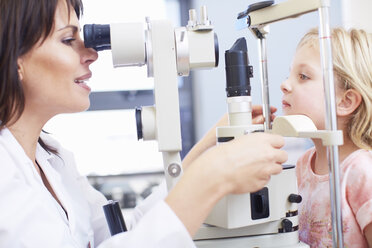 Eye doctor examining girl's vision - ZEF000602