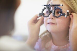 Eye doctor examining girl's vision - ZEF000605