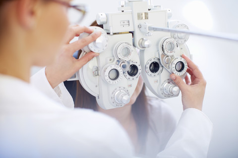 Augenarzt untersucht die Sehkraft einer Frau, lizenzfreies Stockfoto