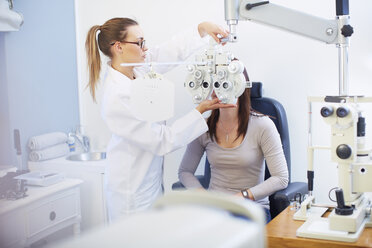 Eye doctor examining woman's vision - ZEF000636