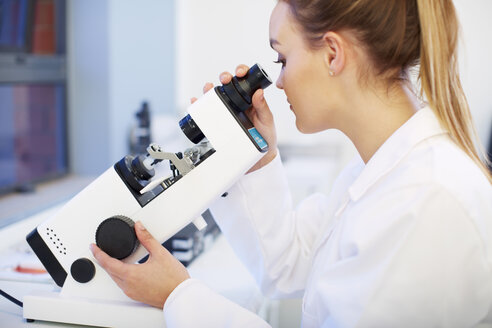 Optometrist looking through microscope - ZEF000616