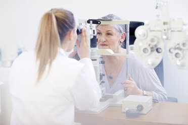 Eye doctor examining senior woman's vision - ZEF000650