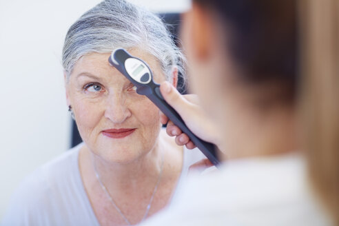 Eye doctor examining senior woman's vision - ZEF000659