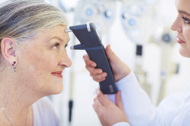 Eye doctor examining senior woman's vision - ZEF000661