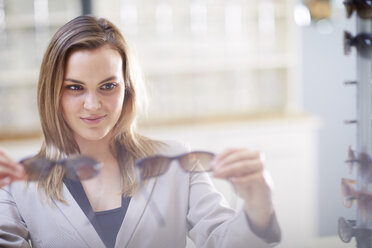 Woman at the optician trying on sunglasses - ZEF000699