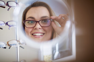 Frau beim Optiker, die eine Brille anprobiert - ZEF000700