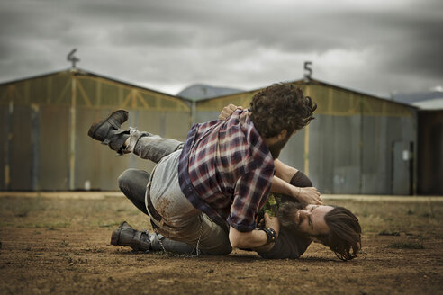 Two men with full beards fighting in abandoned landscape - KOF000010