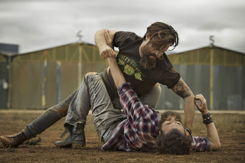 Two men with full beards fighting in abandoned landscape - KOF000011