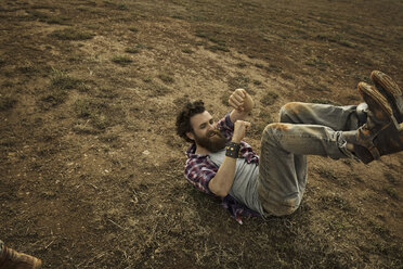 Man with full beard lying on soil - KOF000019