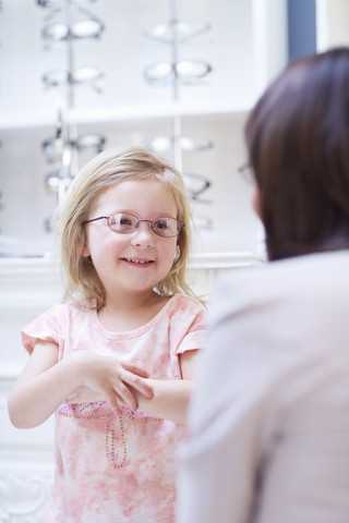 Mädchen beim Optiker, das eine Brille anprobiert, lizenzfreies Stockfoto