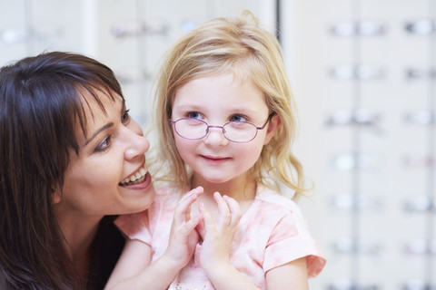 Girl at the optician trying on glasses stock photo