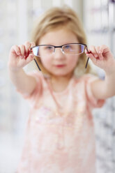 Girl at the optician holding glasses - ZEF000597