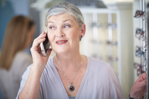 Senior woman at the optician talking on cell phone - ZEF000629