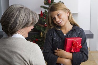 Glückliches Mädchen erhält Weihnachtsgeschenk von der Oma - CHAF000194