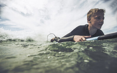 France, Bretagne, Camaret sur Mer, Teenage boy surfing at Atlantic coast - UUF001737