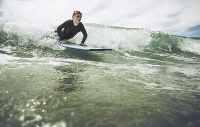 Frankreich, Bretagne, Camaret sur Mer, Jugendlicher beim Surfen an der Atlantikküste - UUF001767