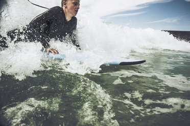 France, Bretagne, Camaret sur Mer, Teenage boy surfing at Atlantic coast - UUF001747