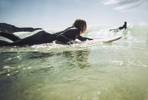 France, Bretagne, Camaret sur Mer, Teenagers surfing at Atlantic coast stock photo