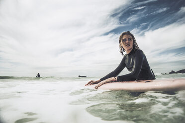 France, Bretagne, Camaret sur Mer, Teenage girl surfing at Atlantic coast - UUF001750