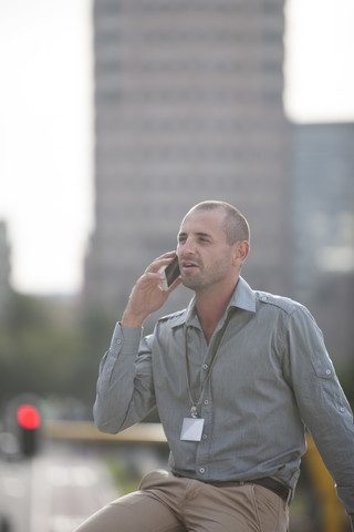Porträt eines Geschäftsmannes, der mit einem Smartphone telefoniert, lizenzfreies Stockfoto