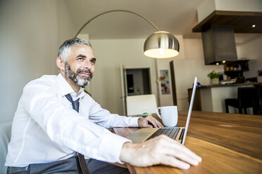 Porträt eines lächelnden Geschäftsmannes, der in seinem Büro zu Hause arbeitet - MBEF001150