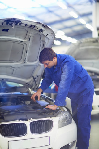 Automechaniker bei der Arbeit in einer Reparaturwerkstatt, lizenzfreies Stockfoto