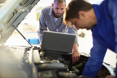 Two car mechanics at work in repair garage - ZEF000536