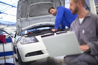 Two car mechanics at work in repair garage - ZEF000538