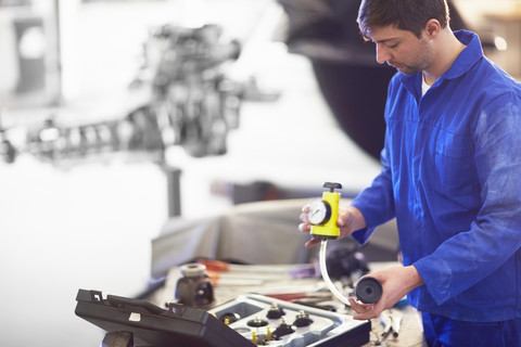 Automechaniker bei der Arbeit in einer Reparaturwerkstatt, lizenzfreies Stockfoto