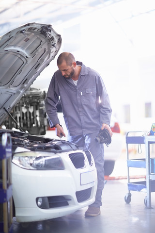 Automechaniker bei der Arbeit in einer Reparaturwerkstatt, lizenzfreies Stockfoto