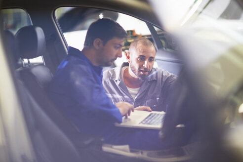 Zwei Automechaniker mit Laptop in der Reparaturwerkstatt - ZEF000514