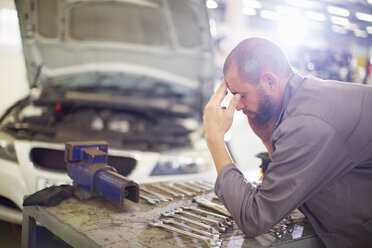 Gestresster Automechaniker in der Reparaturwerkstatt - ZEF000520