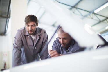 Two car mechanics at work in repair garage - ZEF000521