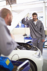 Two car mechanics at work in repair garage - ZEF000524