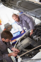 Zwei Automechaniker bei der Arbeit in einer Reparaturwerkstatt - ZEF000546