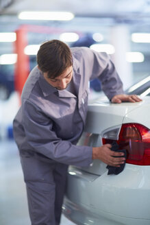 Car mechanic wiping car in repair garage - ZEF000556