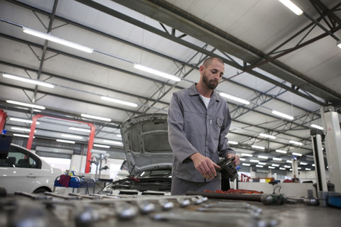 Automechaniker bei der Arbeit in einer Reparaturwerkstatt, lizenzfreies Stockfoto