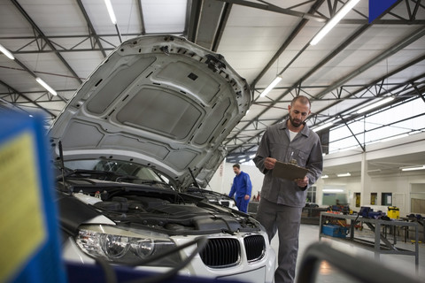 Car mechanic with clipboard in repair garage stock photo