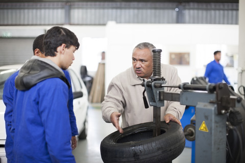 Instructor and trainees in repair garage stock photo