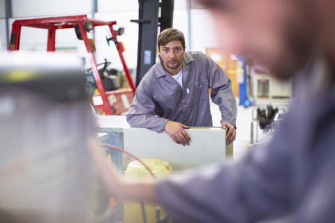 Zwei Arbeiter in einer Fabrik, lizenzfreies Stockfoto