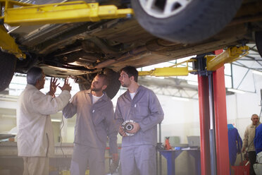 Zwei Automechaniker mit Kunden in einer Reparaturwerkstatt - ZEF000506