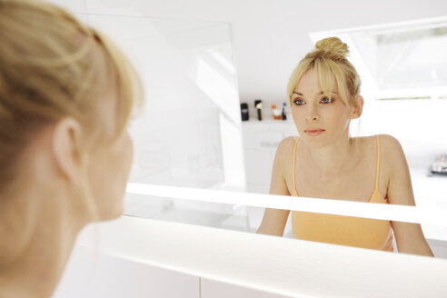 Woman looking at her mirror image in the bathroom - GDF000421