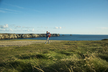 Frankreich, Bretagne, Camaret sur Mer, Älterer Mann beim Wandern an der Atlantikküste - UUF001757