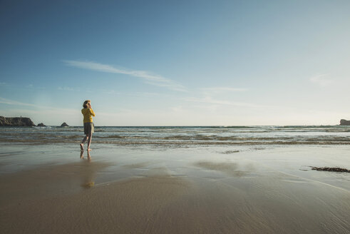 France, Brittany, Camaret-sur-Mer, teenage girl standing on beach - UUF001786