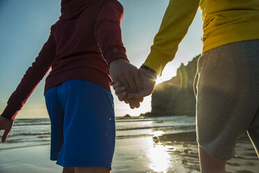 France, Brittany, Camaret-sur-Mer, teenage couple hand in hand on the beach - UUF001795