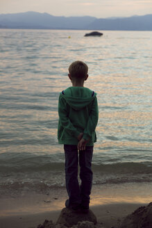 Italien, Gardasee, Junge mit Blick auf den Sonnenuntergang - SARF000841