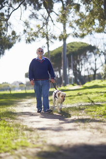 Visually impaired man walking with his guide dog in a park - ZEF000985
