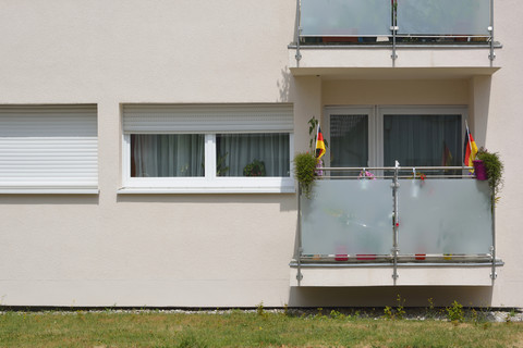 Deutschland, Bayern, Balkon mit zwei Blumentöpfen und zwei kleinen deutschen Fahnen, lizenzfreies Stockfoto